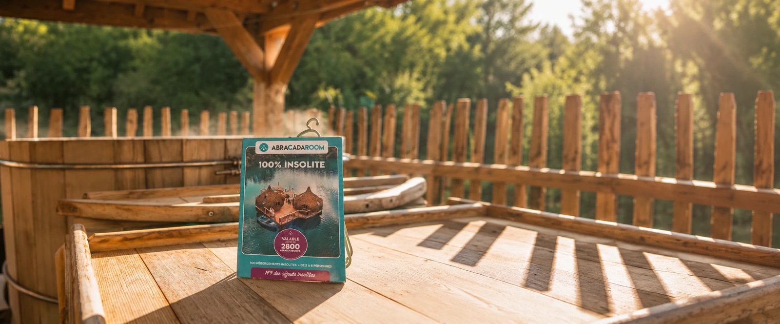 Coffret cadeau AbracadaRoom posé sur la terrasse d'un hébergement avec bain nordique